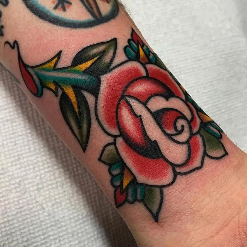 a tattoo of a rose in a person's wrist