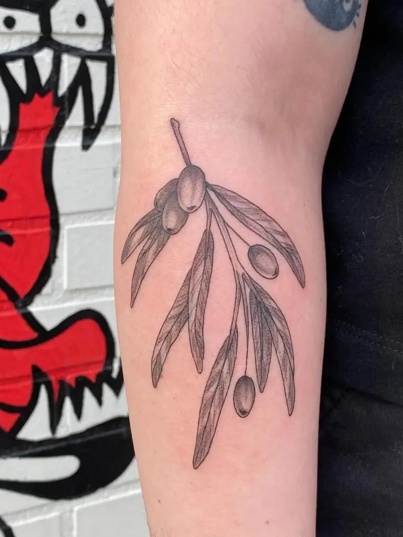 a tattoo of leaves on a person's arm