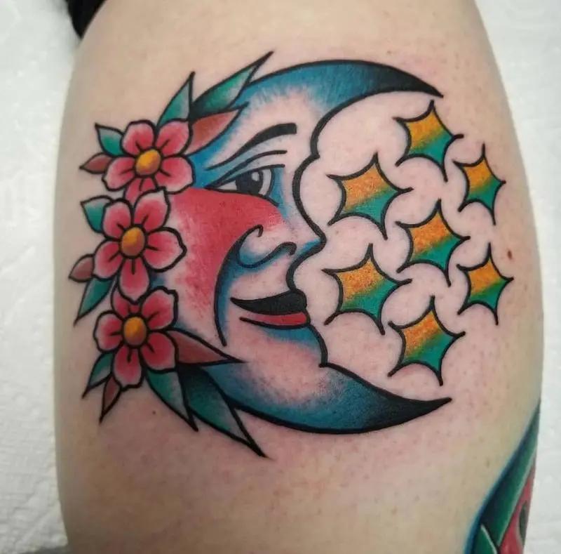 a tattoo of a moon and flowers