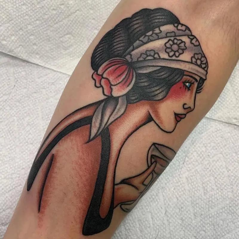 a tattoo of a woman holding a glass