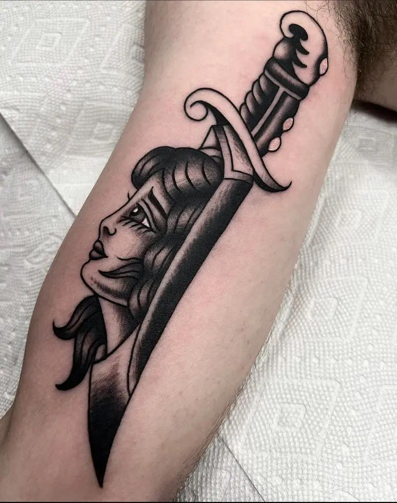 a tattoo of a knife and a woman 